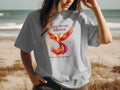 Light grey t-shirt with a phoenix design and the text "Rising Beyond Silence".
