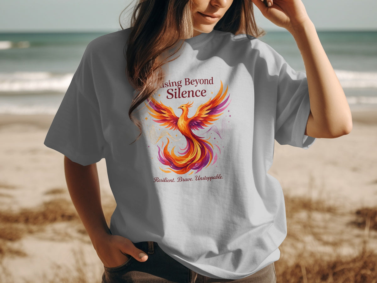 Light grey t-shirt with a phoenix design and the text "Rising Beyond Silence".