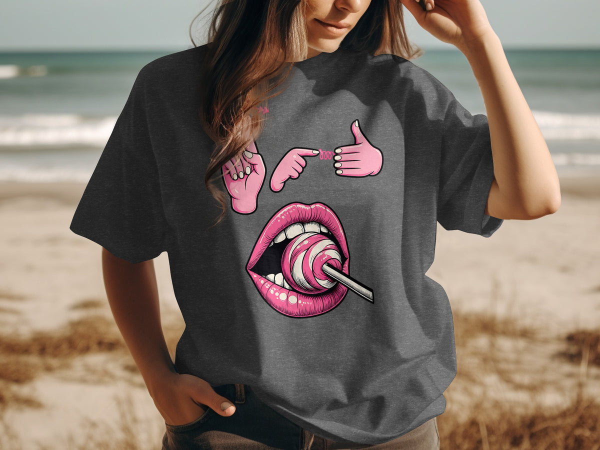 Pink graphic of lips with lollipop, pointing finger, and thumbs-up on dark t-shirt.