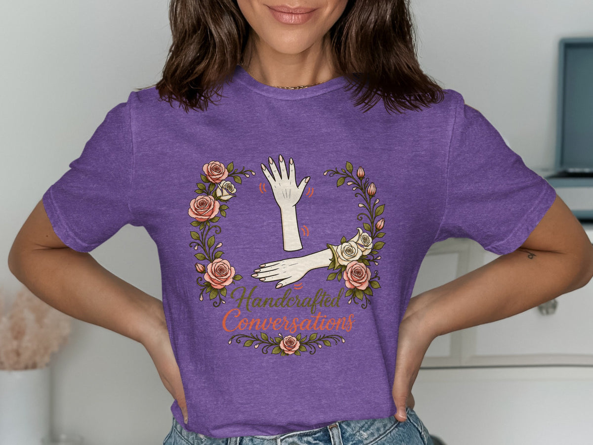 Purple t-shirt with floral wreath and "Handcrafted Conversations" text.