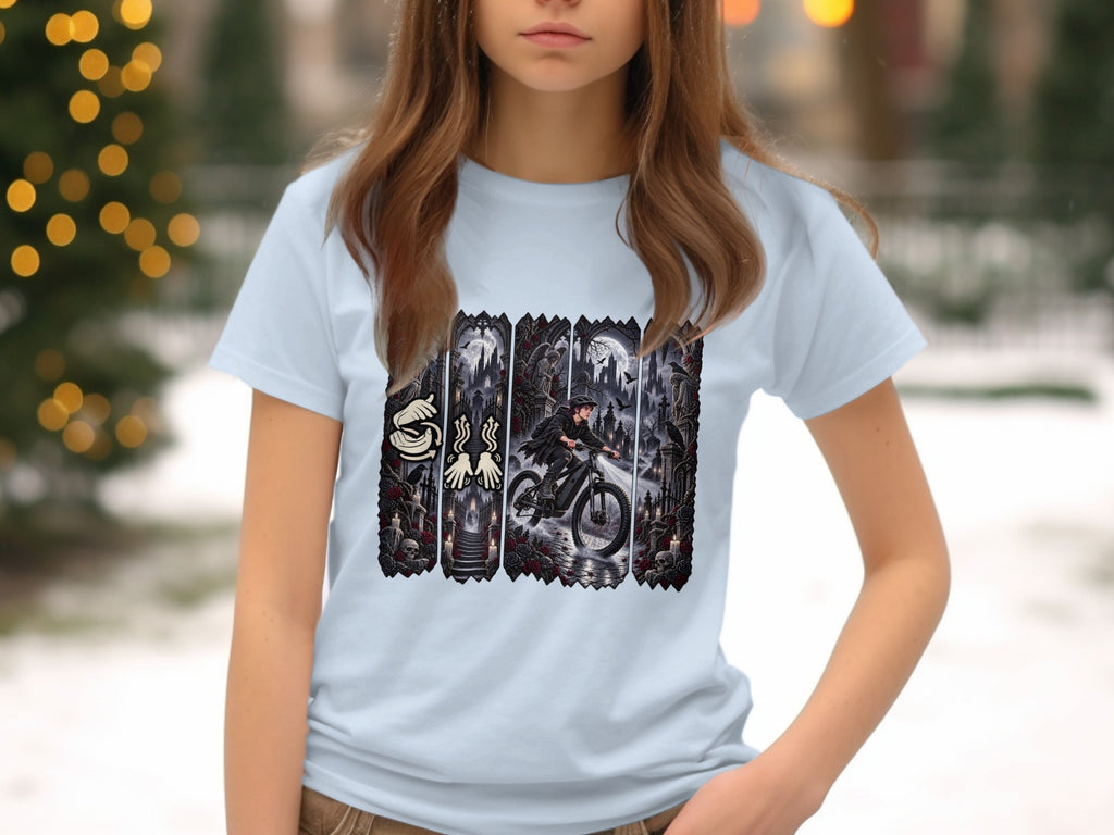 Light blue t-shirt with a graphic depicting a person riding a bicycle through a dark, gothic scene.