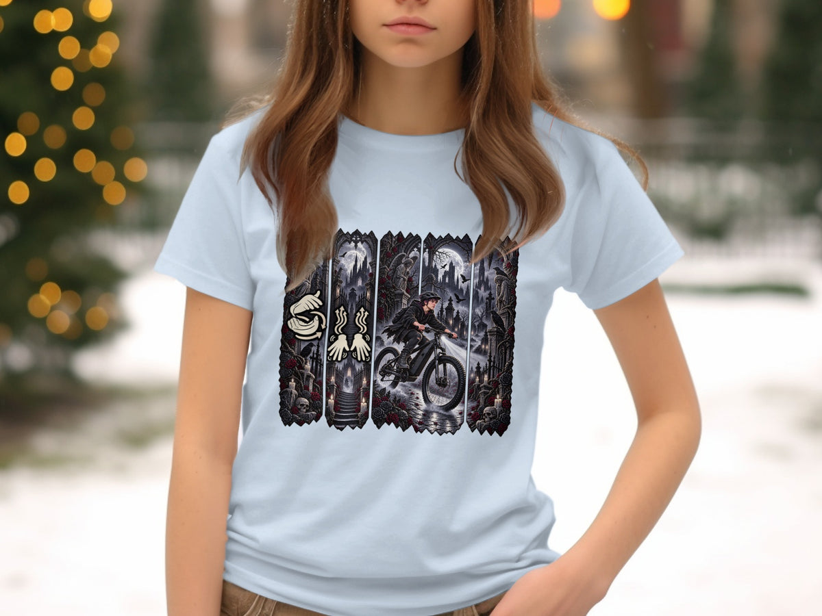 Light blue t-shirt with a graphic depicting a person riding a bicycle through a dark, gothic scene.