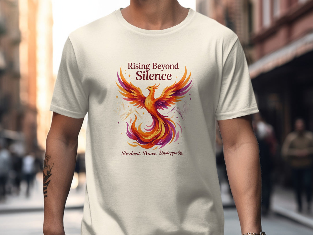 Cream t-shirt with a phoenix graphic and text "Rising Beyond Silence."