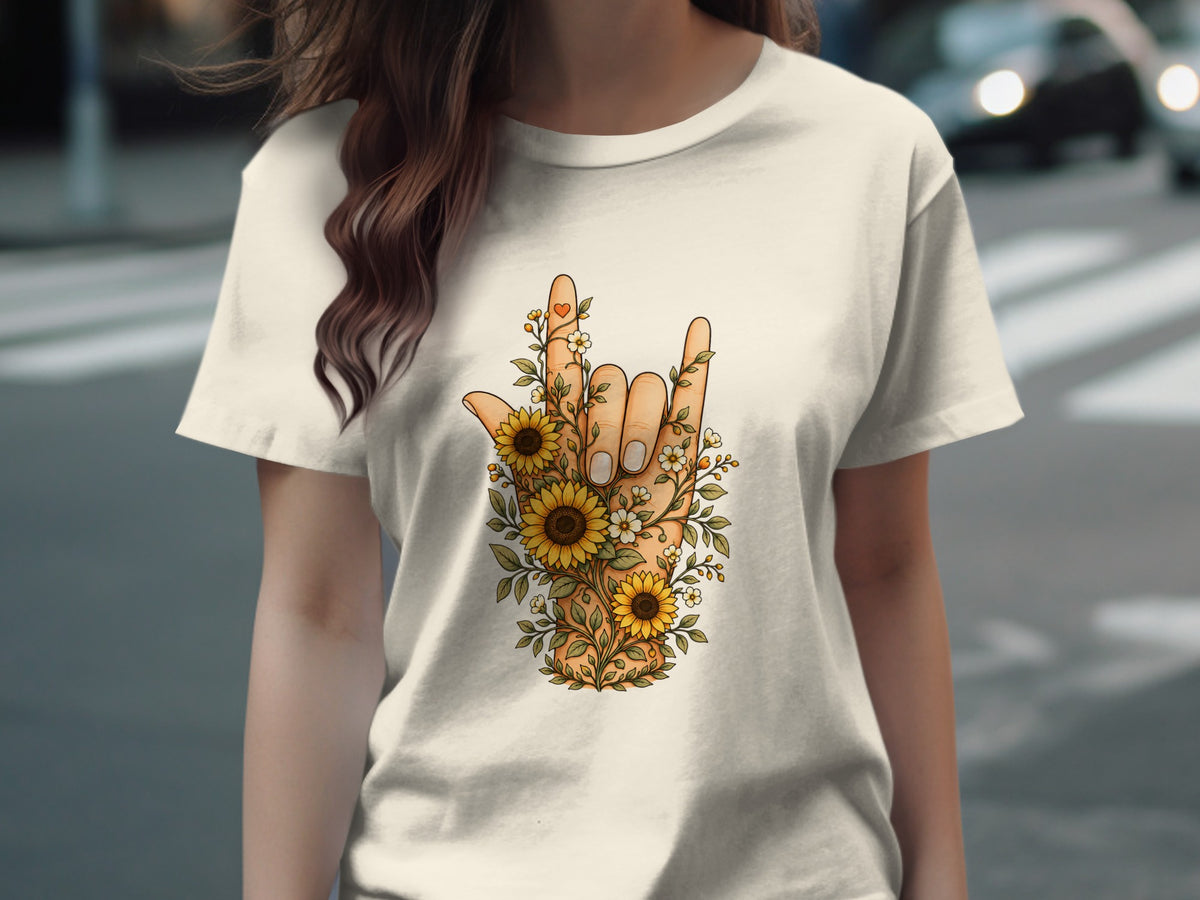 T-shirt with hand gesture of rock on graphic surrounded by sunflowers and greenery.