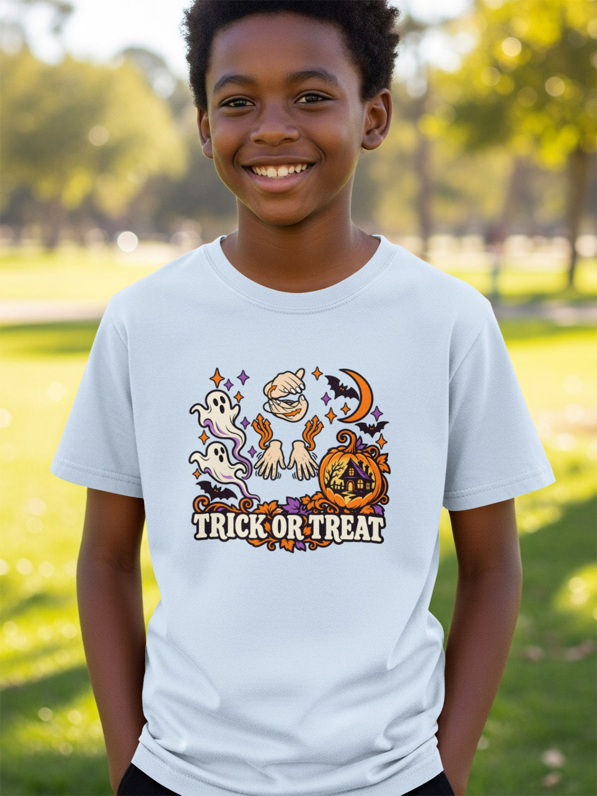 Boy wearing a light blue t-shirt with a Halloween graphic of ghosts, pumpkin, and text.