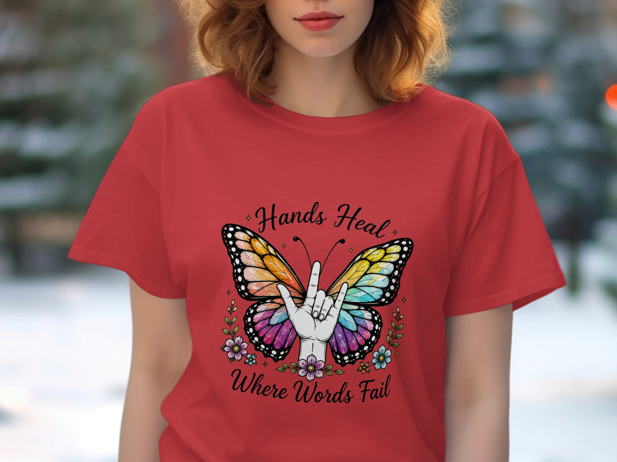 Red t-shirt with butterfly, hands, and text "Hands Heal Where Words Fail."