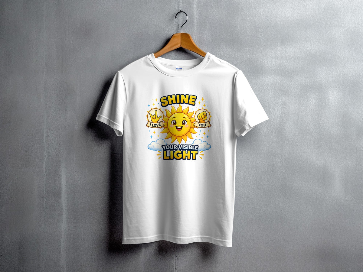 White t-shirt with a cartoon sun, clouds, and text "SHINE I LOVE YOU YOUR VISIBLE LIGHT".