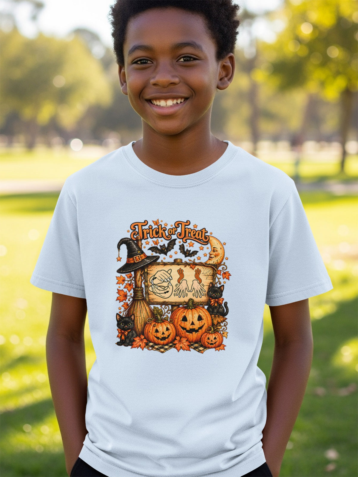 Light blue t-shirt with Halloween "Trick or Treat" graphic featuring pumpkins, witch hat, and black cats.