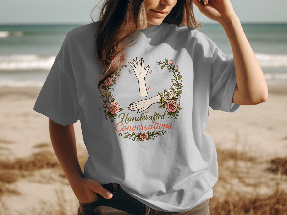 T-shirt graphic with hands in a floral wreath and text "Handcrafted Conversations."