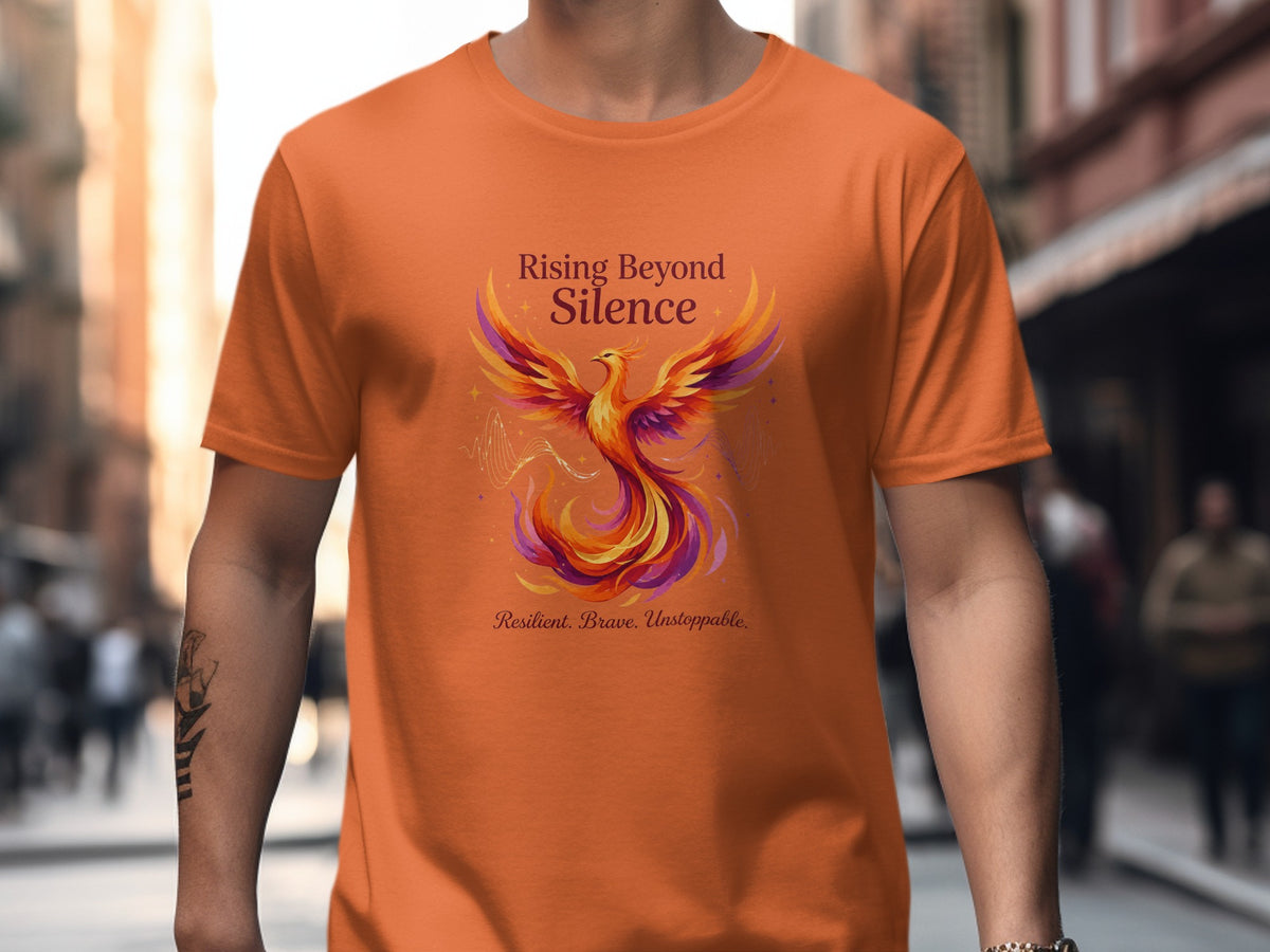 Orange t-shirt with a colorful phoenix and text "Rising Beyond Silence".