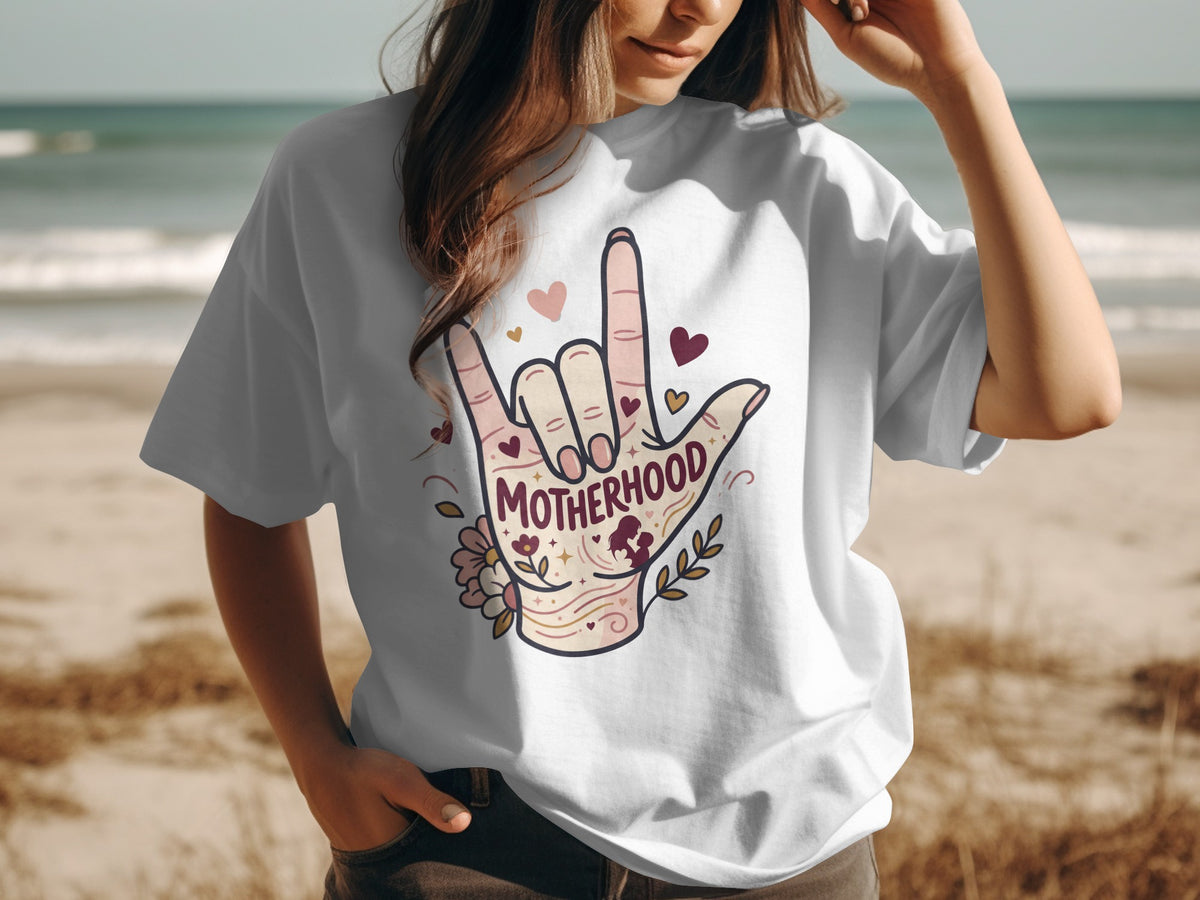 White t-shirt with "Motherhood" hand gesture graphic and hearts.