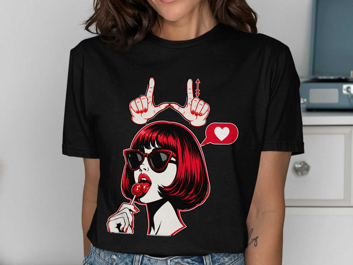 Black t-shirt with pop art graphic of a woman with red hair and sunglasses eating a lollipop.