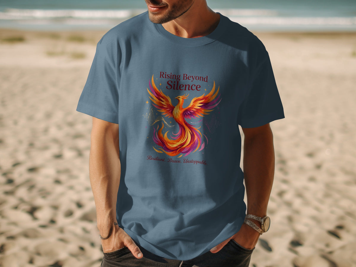 Blue t-shirt with a phoenix graphic and text "Rising Beyond Silence" and "Resilient, Brave, Unstoppable."