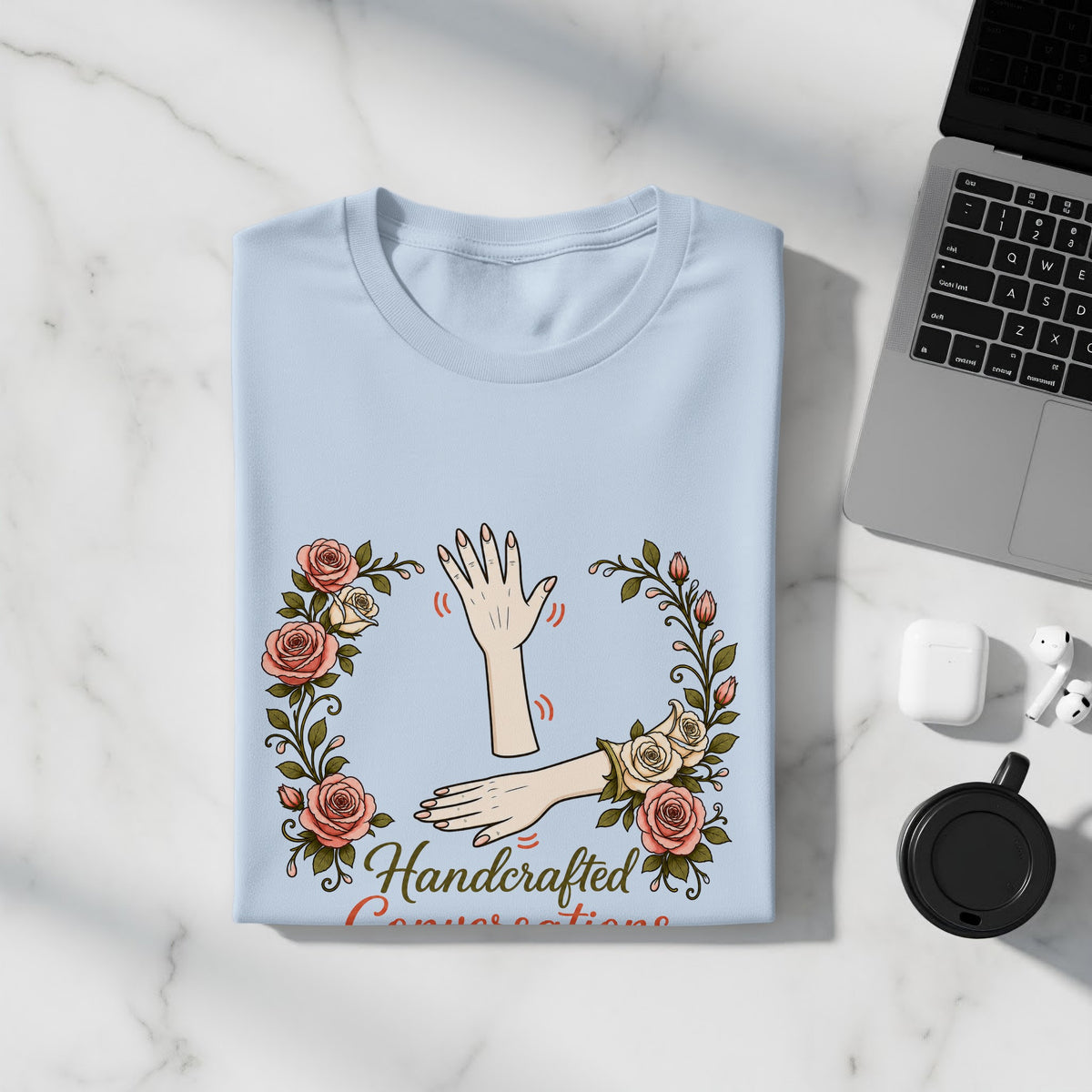 Light blue t-shirt with floral frame and "Handcrafted Conversations" text.