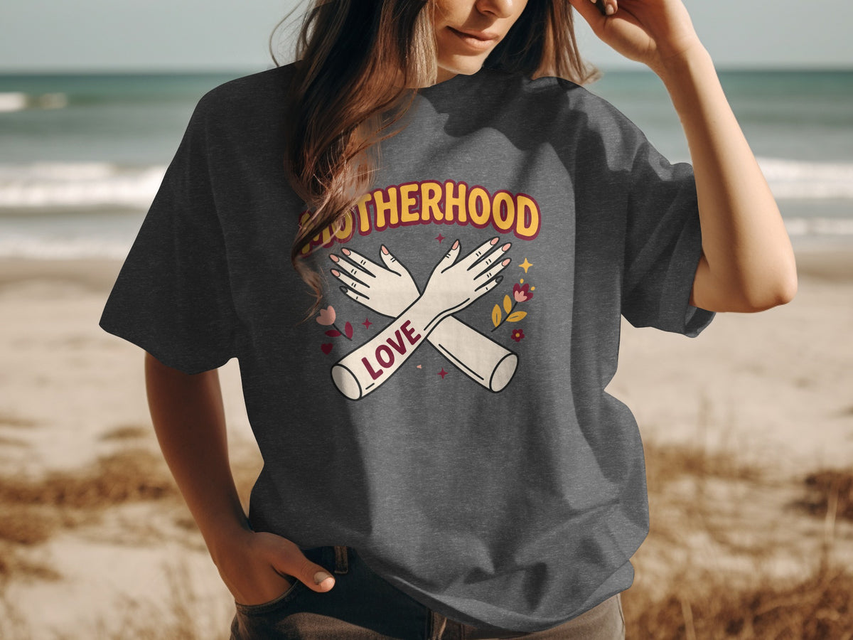 Dark gray t-shirt with "Motherhood" text, crossed arms, and floral accents.