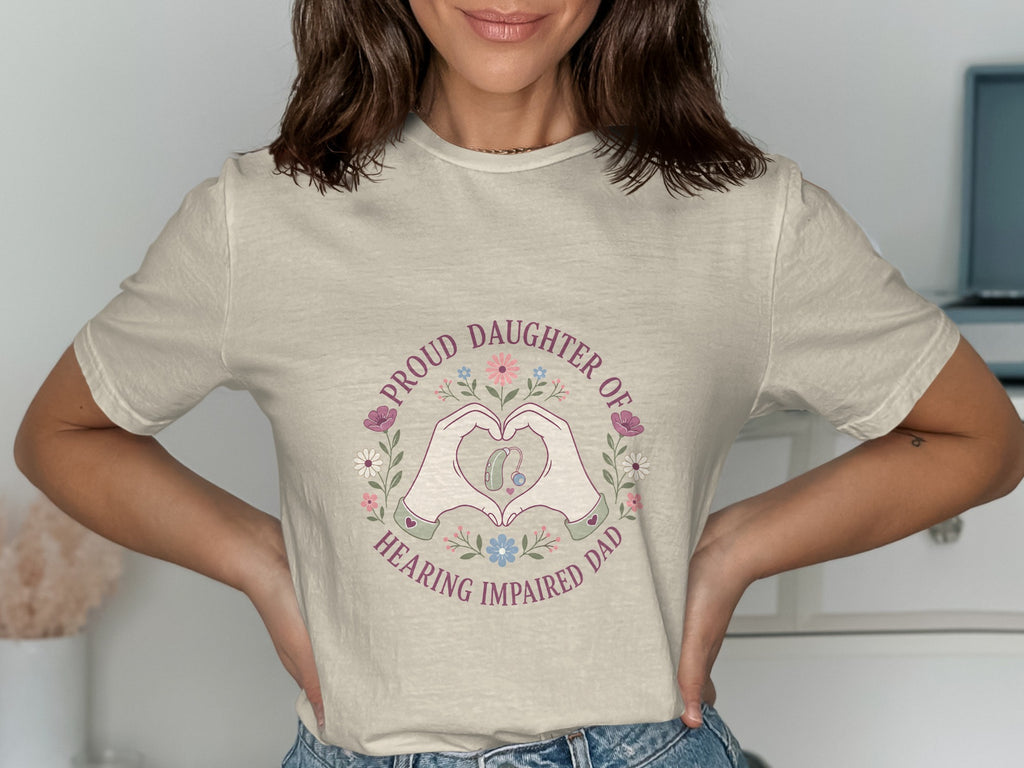 T-shirt with "Proud Daughter of Hearing Impaired Dad" text and heart hands around hearing aid.