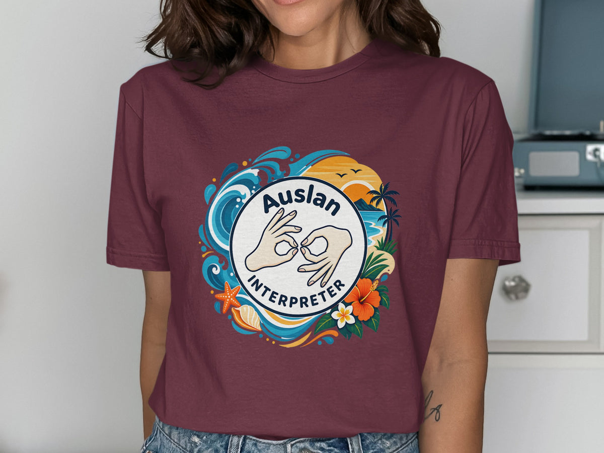 Maroon t-shirt with "Auslan Interpreter" text and a circular design of hands, waves, sunset, and tropical flowers.