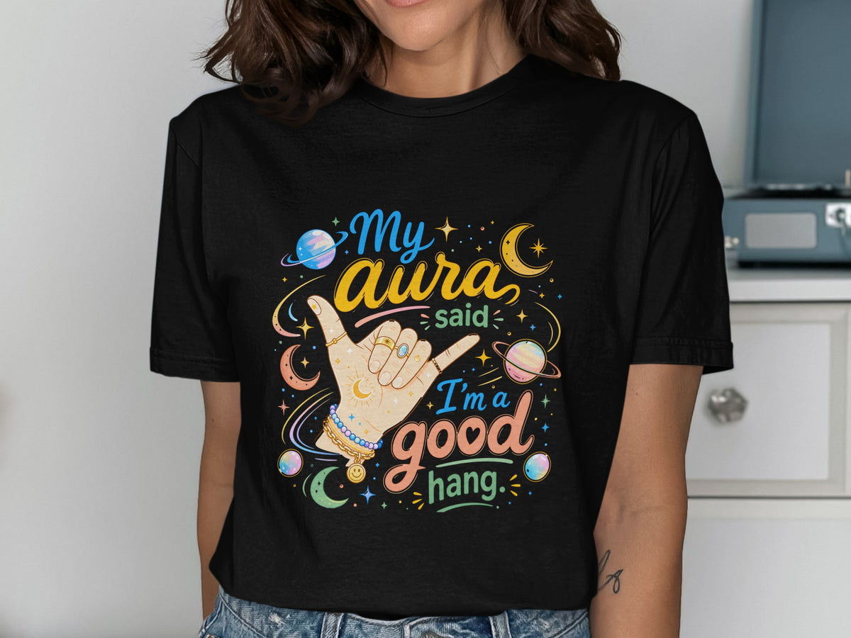 Black t-shirt with "My aura said I'm a good hang" and celestial graphics.