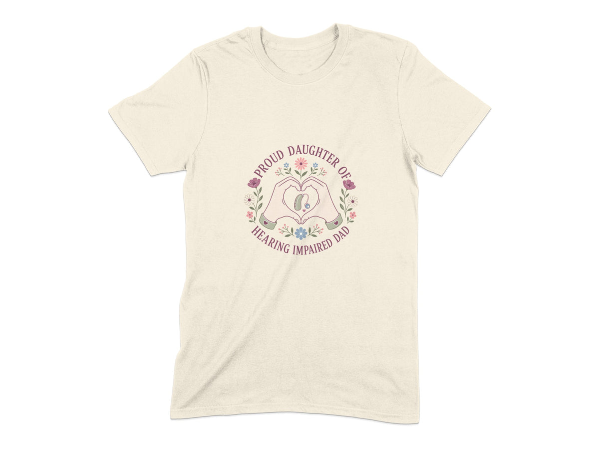 Cream t-shirt with a heart shape formed by hands, enclosing a hearing aid and flowers. Text reads "Proud Daughter of Hearing Impaired Dad".