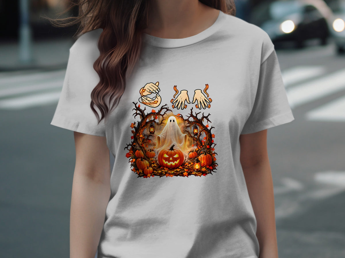 Halloween graphic on a t-shirt with ghost, pumpkins, and autumn leaves.