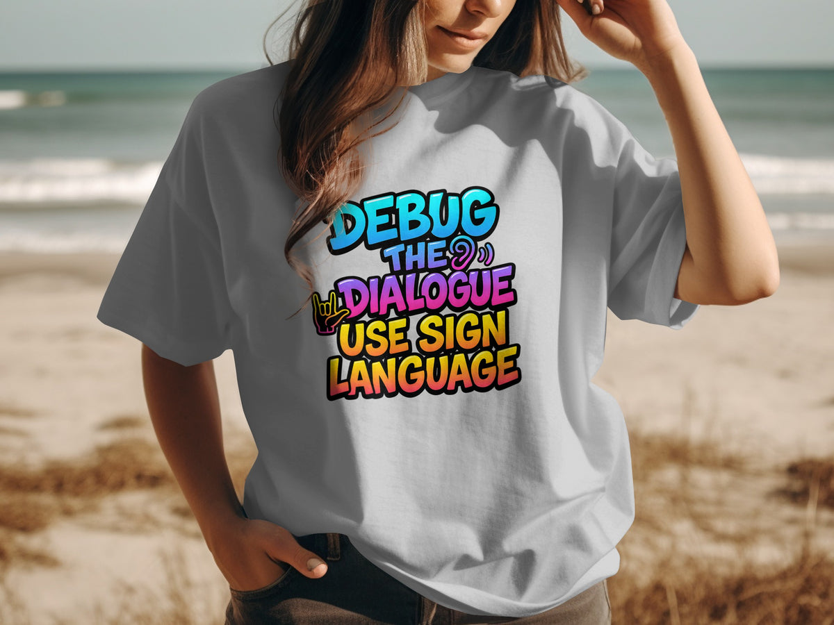 Gray t-shirt with "DEBUG THE DIALOGUE USE SIGN LANGUAGE" text in colorful gradient letters.