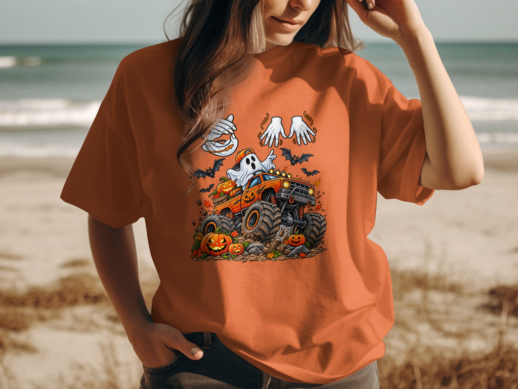 Halloween t-shirt design featuring a ghost driving a monster truck with pumpkins and bats.