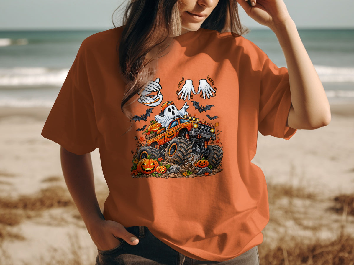 Halloween t-shirt design featuring a ghost driving a monster truck with pumpkins and bats.