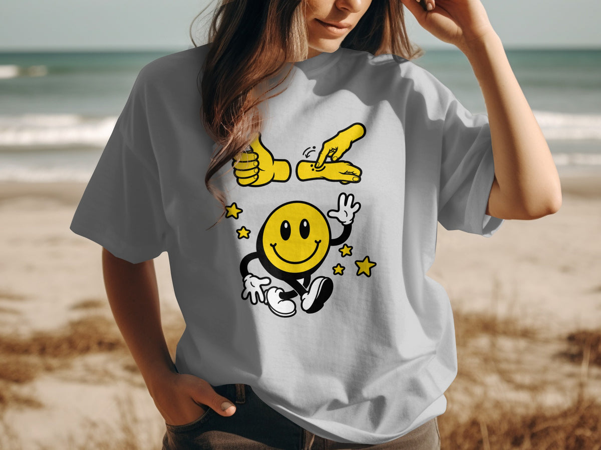 Yellow smiley face with stars and a hand gesture graphic on a grey t-shirt.