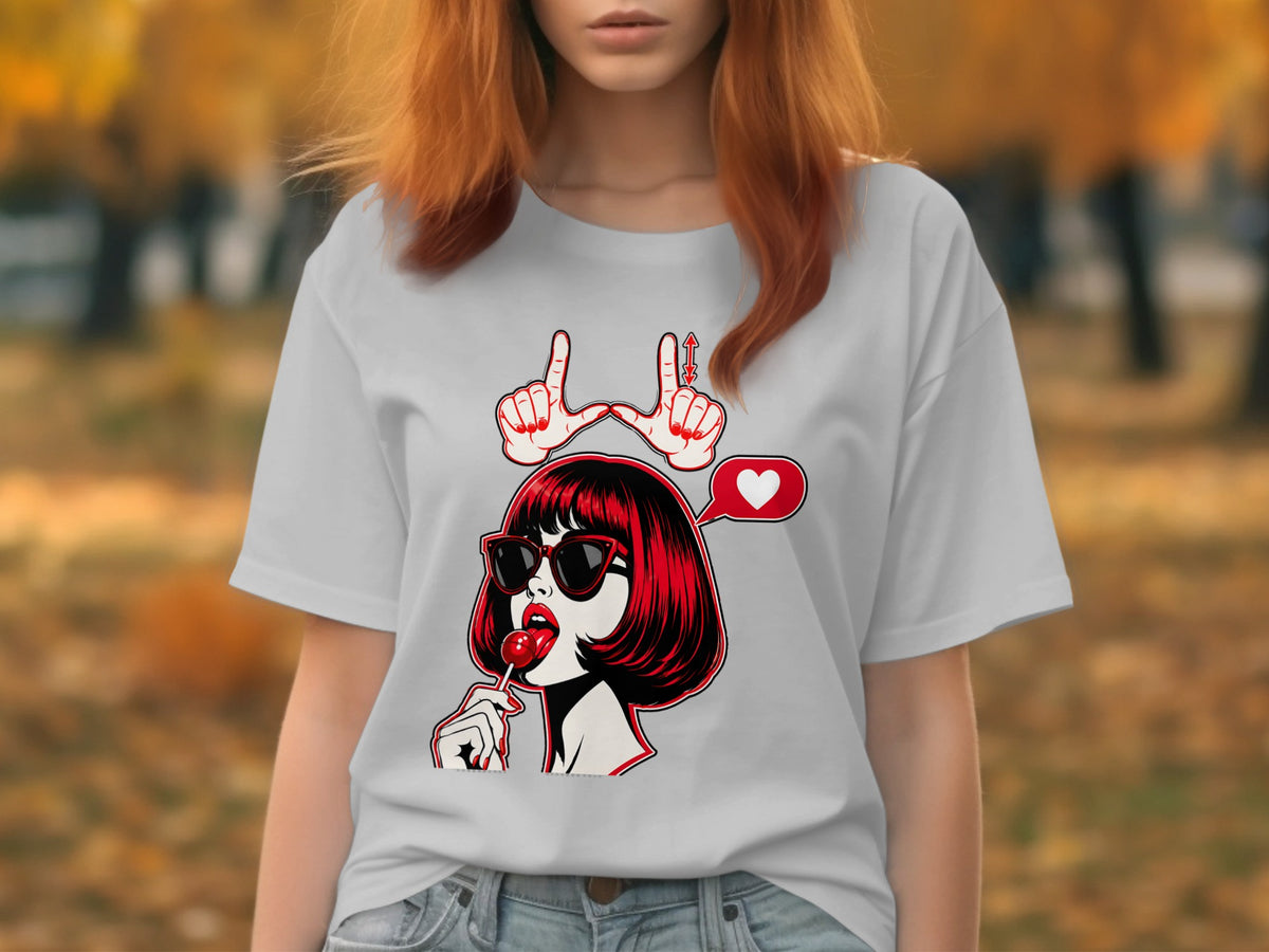 White t-shirt with a graphic of a woman with red hair, sunglasses, and lollipop, and hands forming "love" sign.