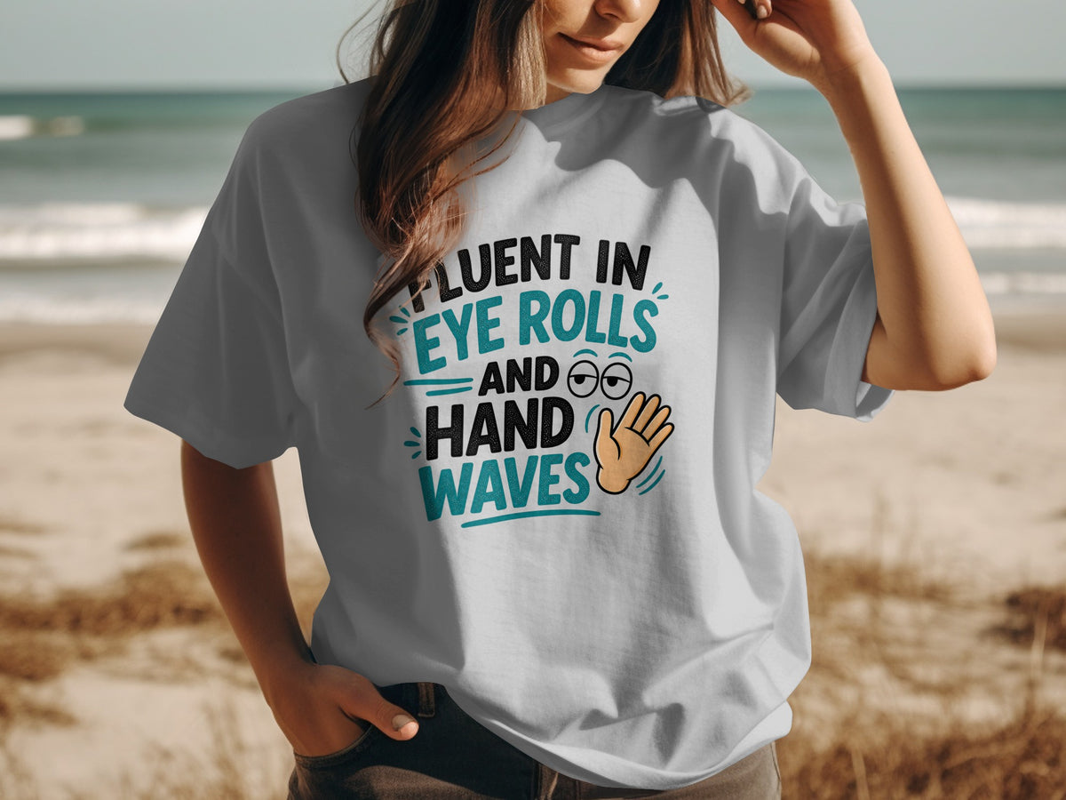 White t-shirt with text "Fluent in Eye Rolls and Hand Waves" and graphics.