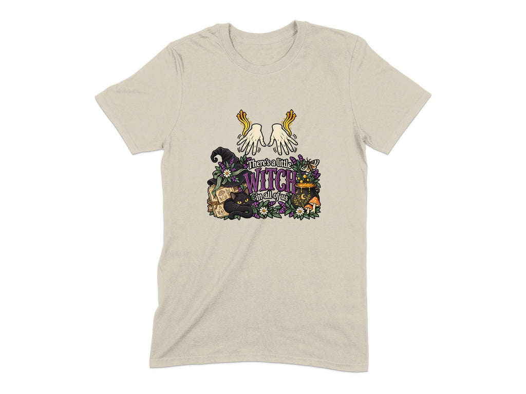 T-shirt with witchy illustration including black cat, cauldron, and text "There's a little witch in all of us".