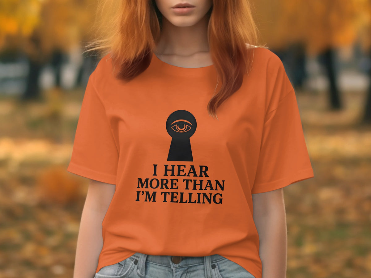 Orange t-shirt with a keyhole graphic and the text "I hear more than I'm telling".