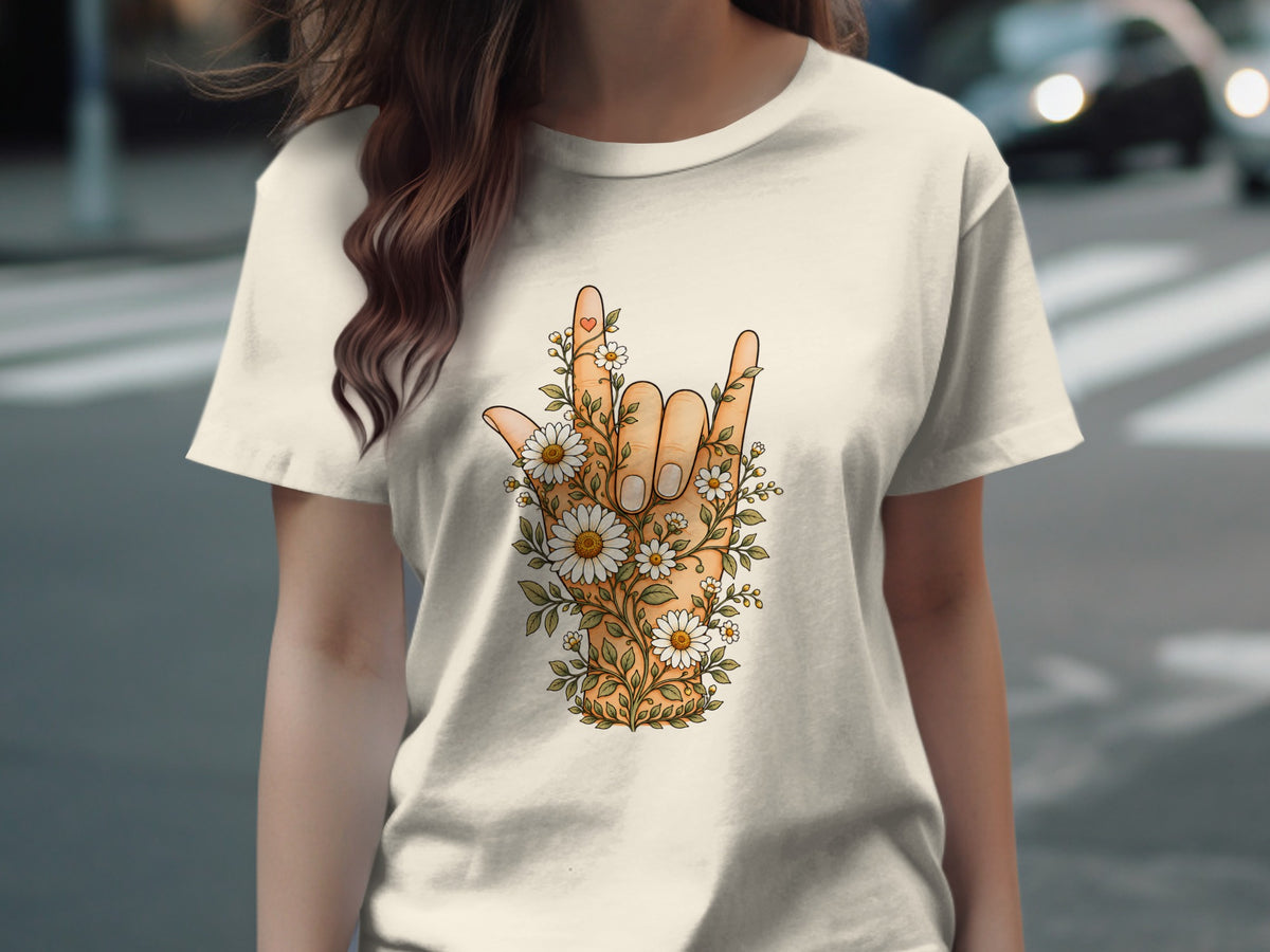 T-shirt with hand making rock on gesture, surrounded by daisies and greenery.