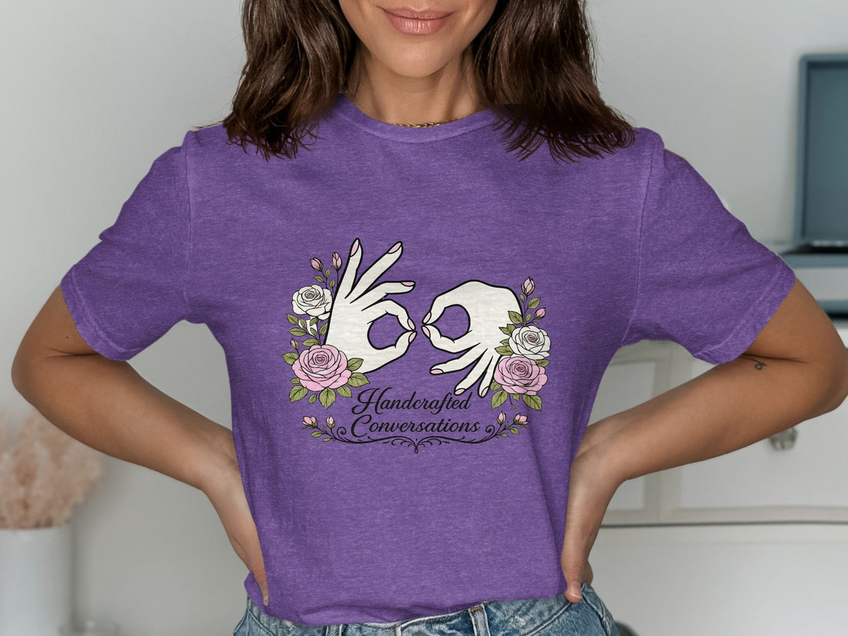Purple t-shirt with hands forming sign language symbols and text "Handcrafted Conversations."