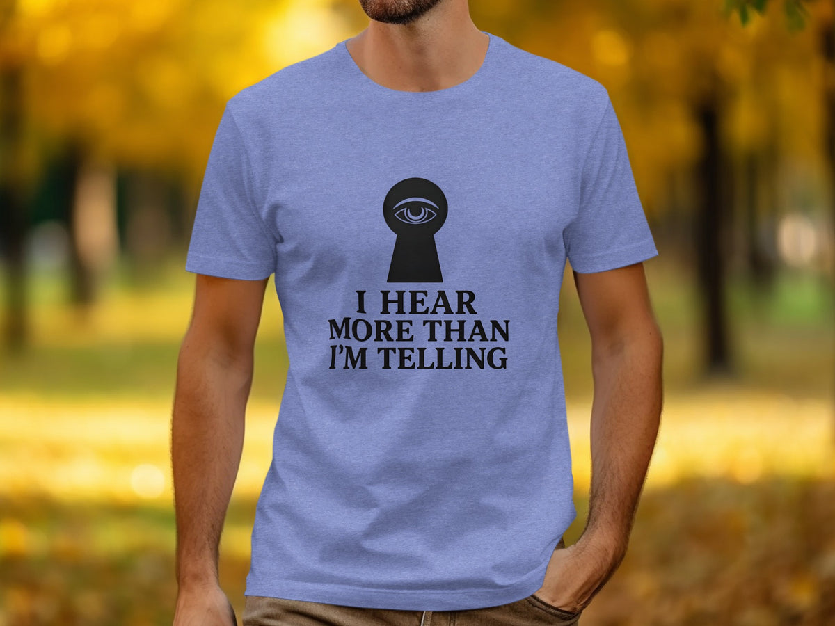 Periwinkle t-shirt with black keyhole eye logo and text "I HEAR MORE THAN I'M TELLING."