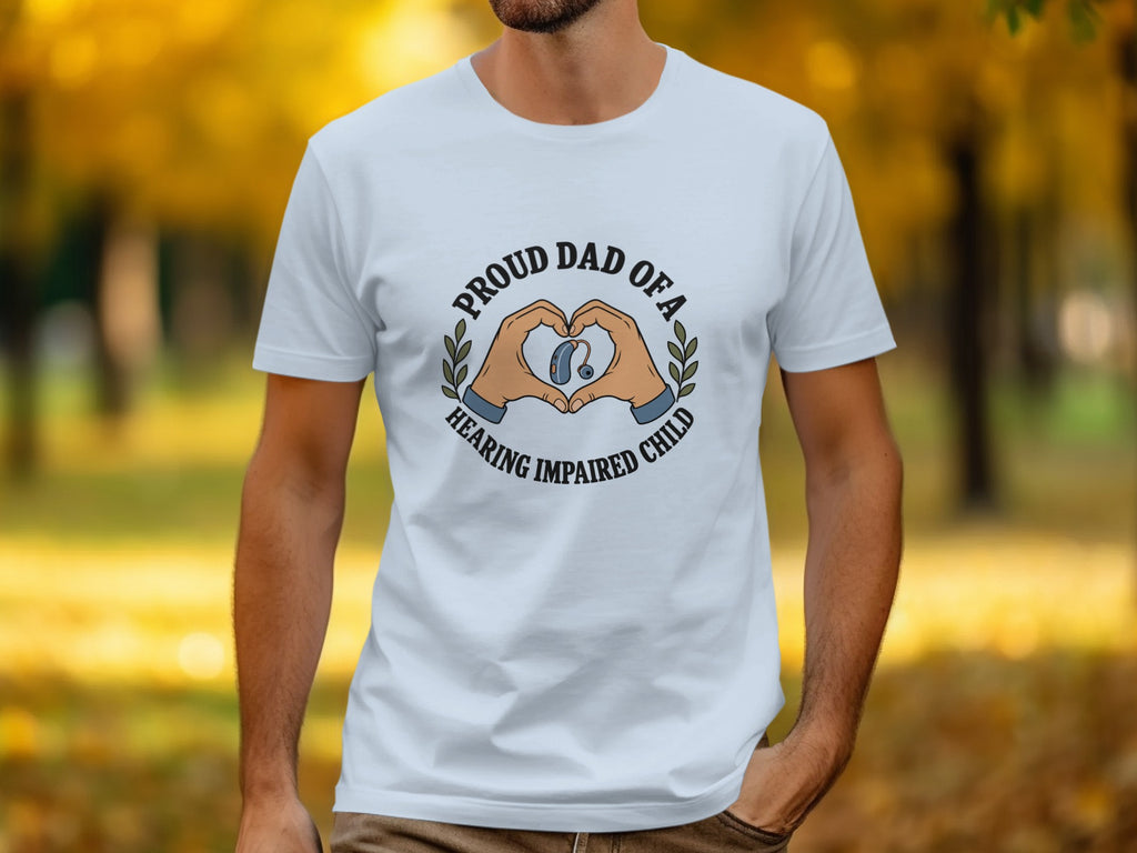White t-shirt with "Proud Dad of a Hearing Impaired Child" text and heart hands with hearing aid graphic.