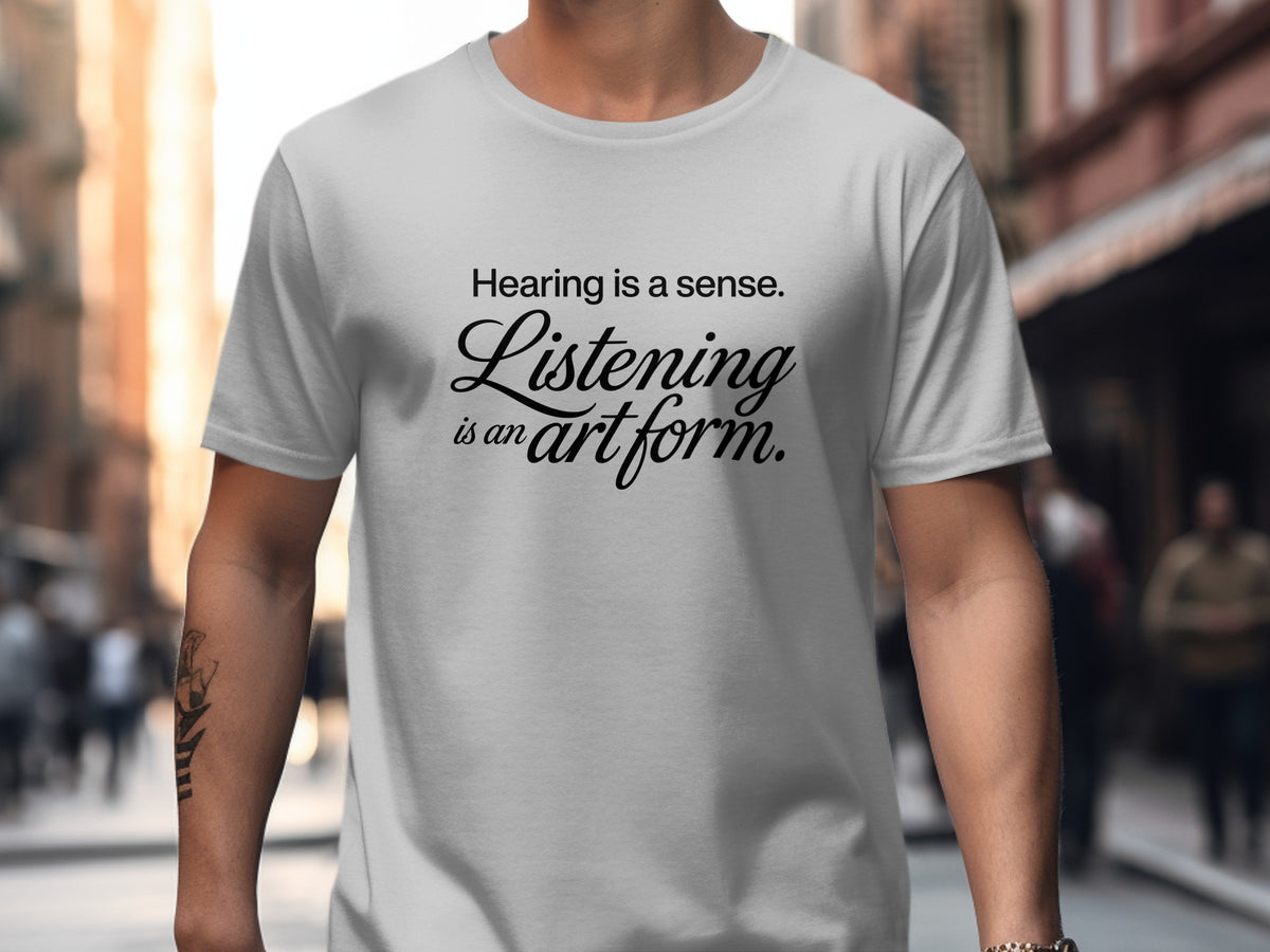 Light gray t-shirt with "Hearing is a sense. Listening is an art form." text.
