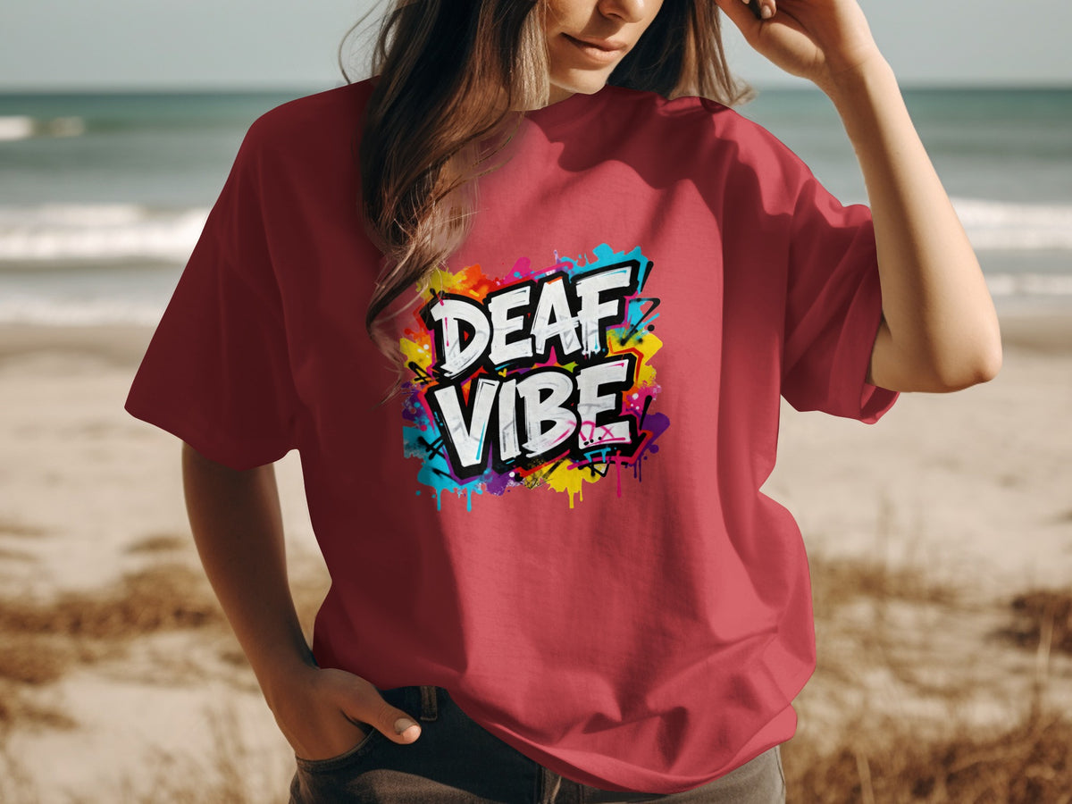 Red t-shirt with graffiti-style text reading "DEAF VIBE" against a beach background.