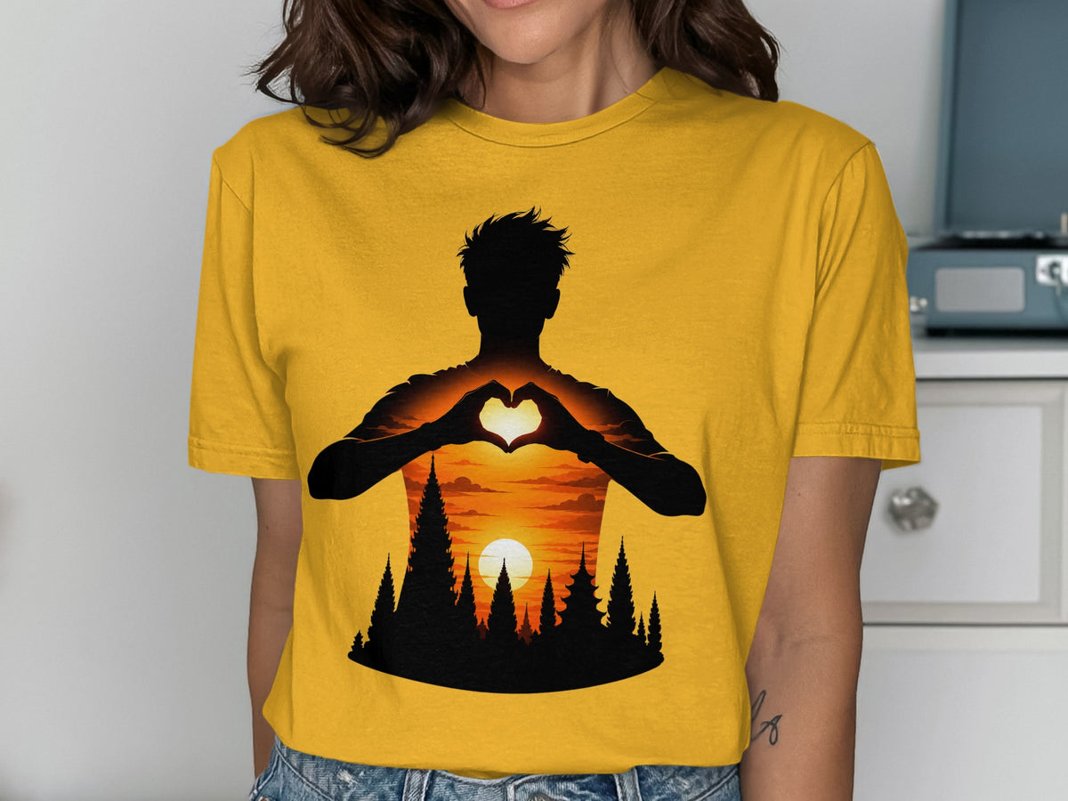 Silhouette of person making heart shape with hands over sunset landscape with trees.