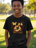 A young boy smiling while wearing a black t-shirt featuring a Halloween witch graphic.