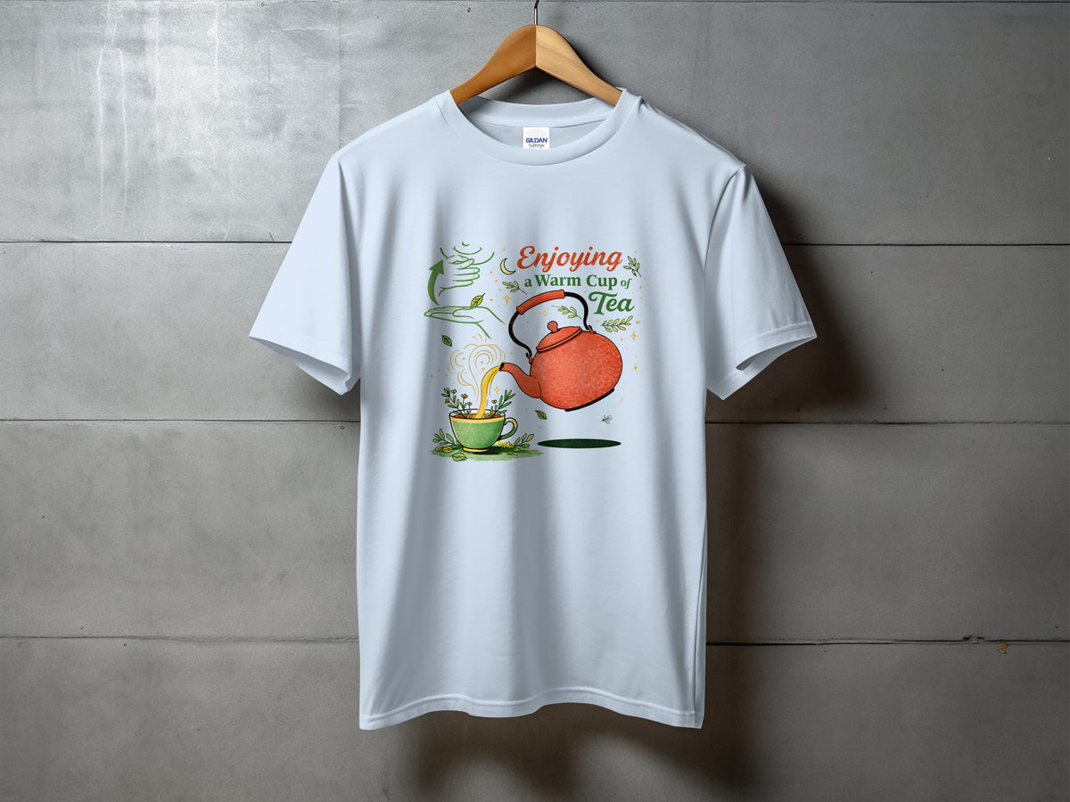 White t-shirt with graphic of orange teapot pouring tea into a green cup, text "Enjoying a Warm Cup of Tea."