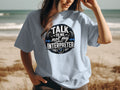 Light blue t-shirt with "Talk To Me, Not My Interpreter" text and headphones graphic.