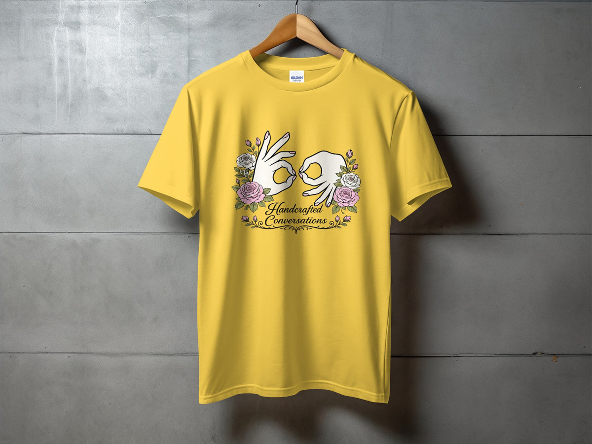 Yellow t-shirt with ASL hands and "Handcrafted Conversations" text and floral design.