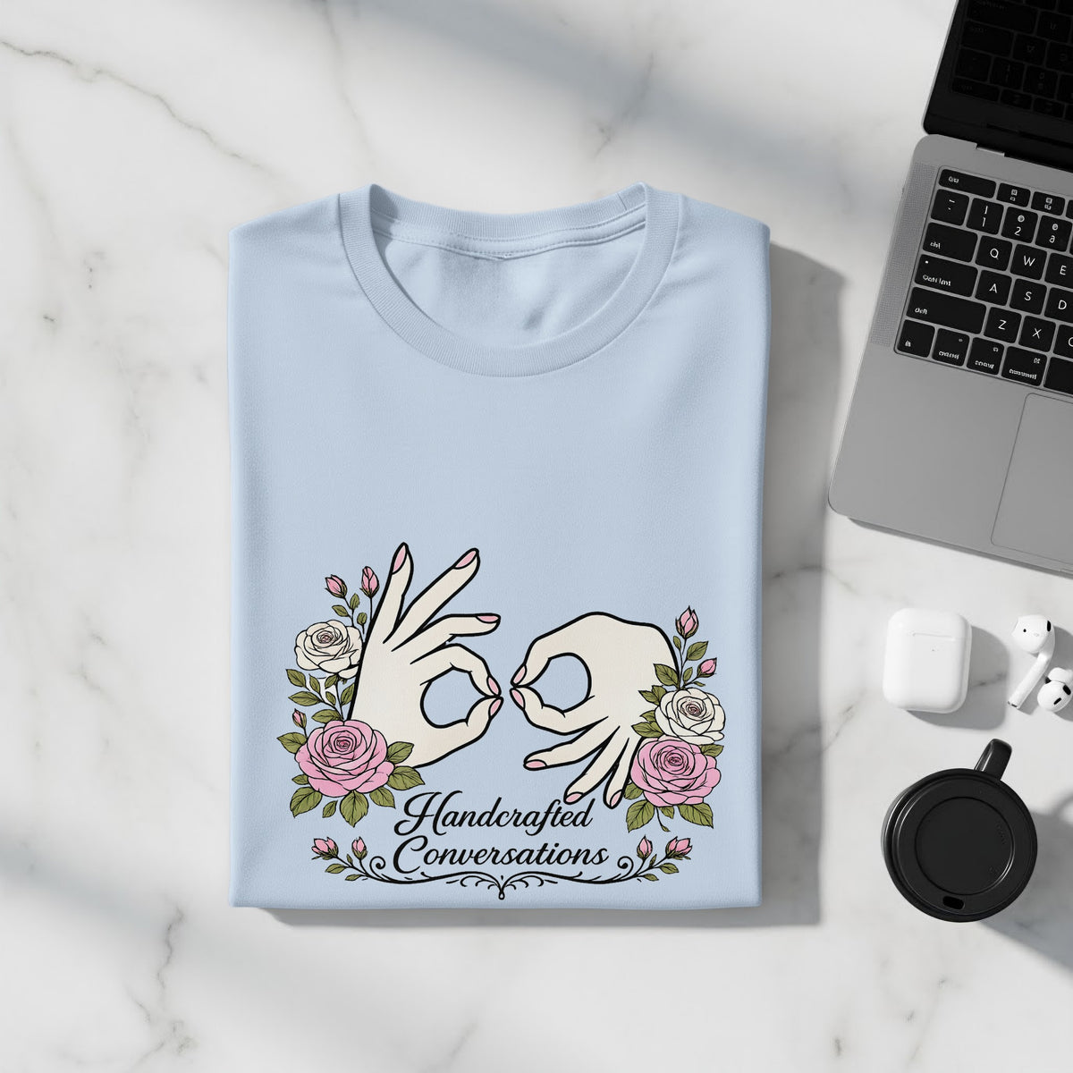 Light blue t-shirt with "Handcrafted Conversations" and floral sign language graphics.