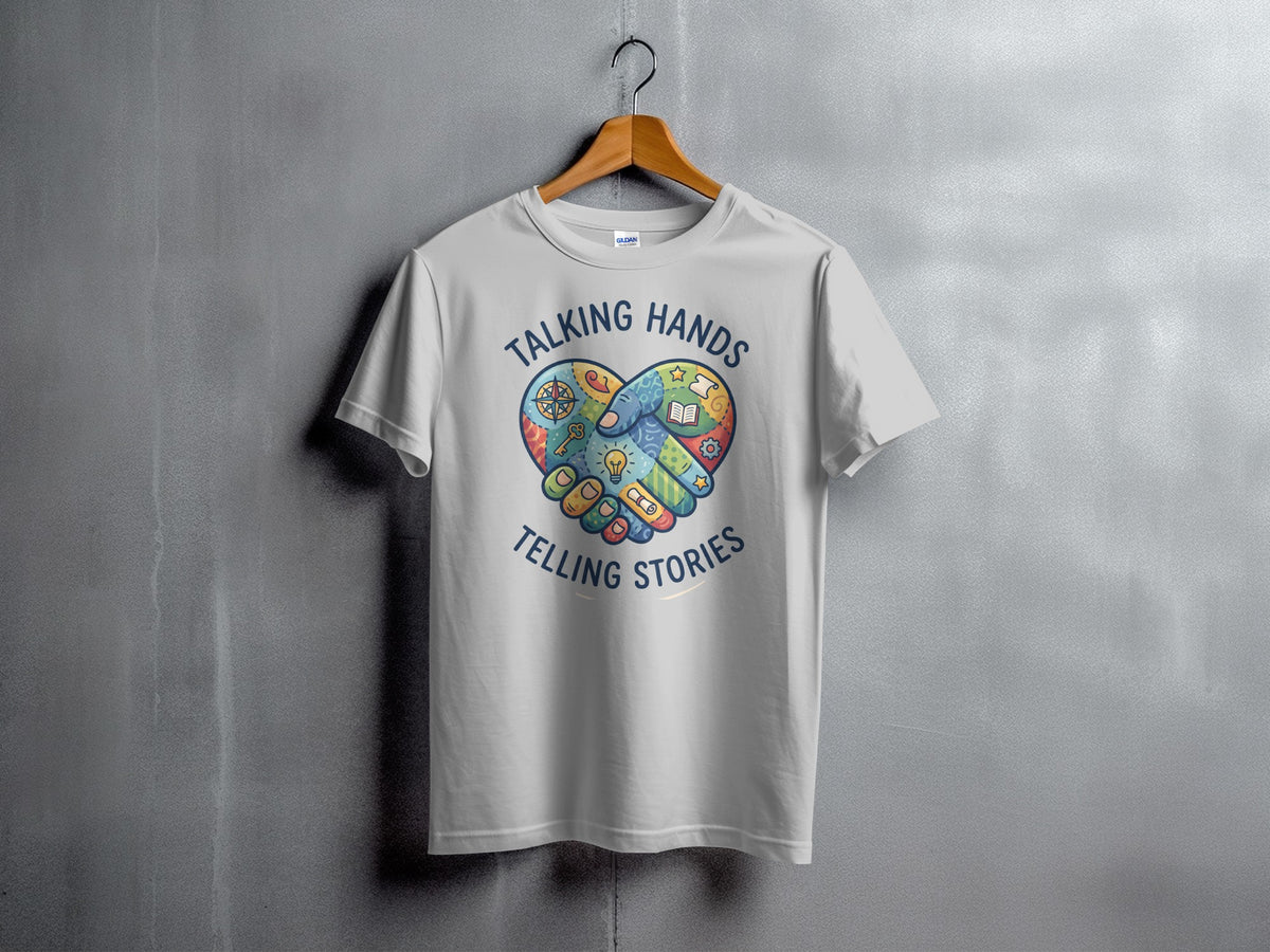 White t-shirt with colorful heart handshake graphic and text "TALKING HANDS TELLING STORIES".