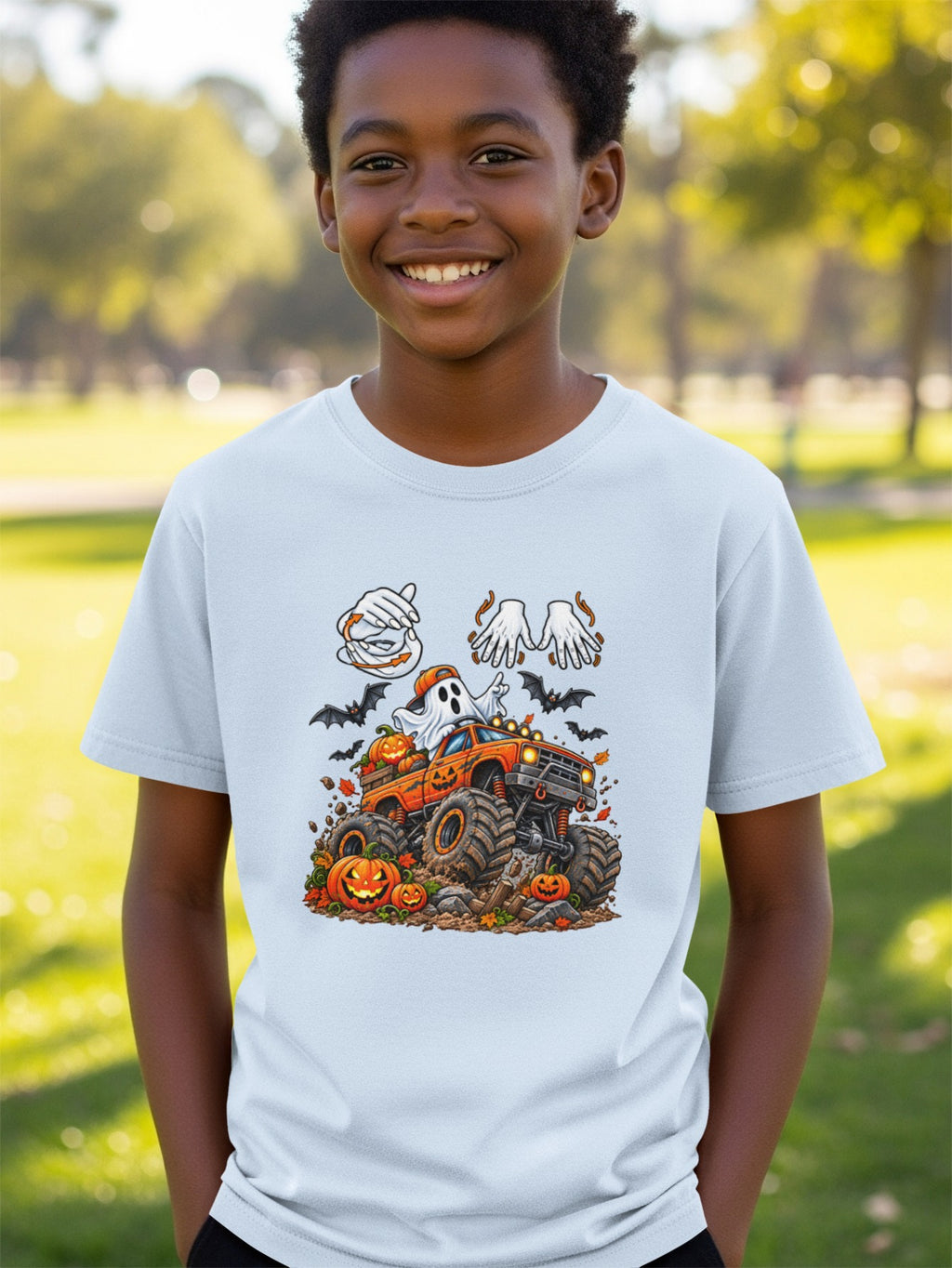Boy wearing a light blue t-shirt with a Halloween monster truck and ghost graphic.